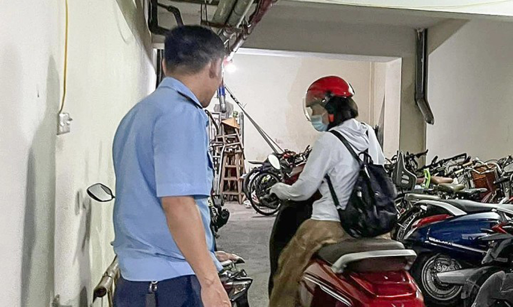 Dắt xe máy, vác pin 20 kg lên tầng 5 để sạc điện